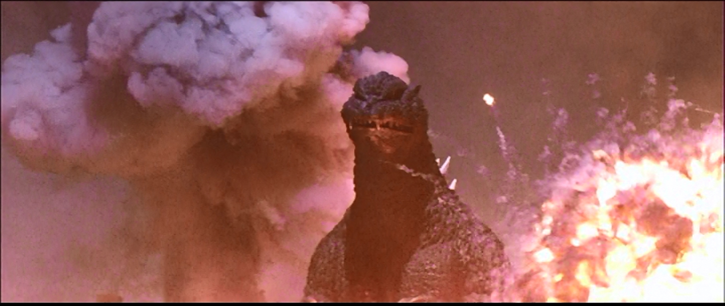 Godzilla, walking through explosions