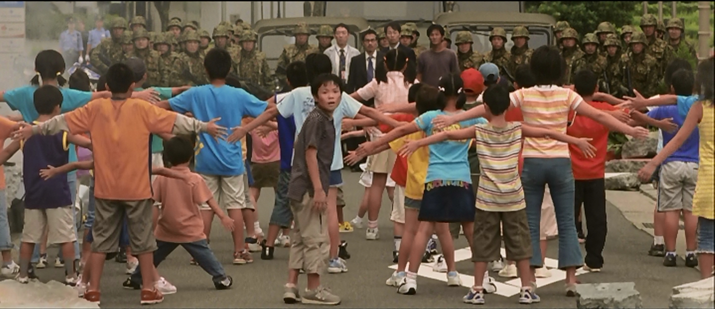 Kids forming a blockade between Gamera and the military.