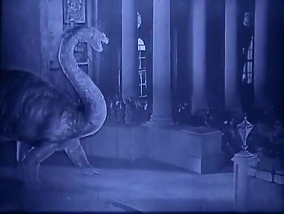 In the foreground, a dinosaur.  In the background, actors. From the 1925's The Lost World.